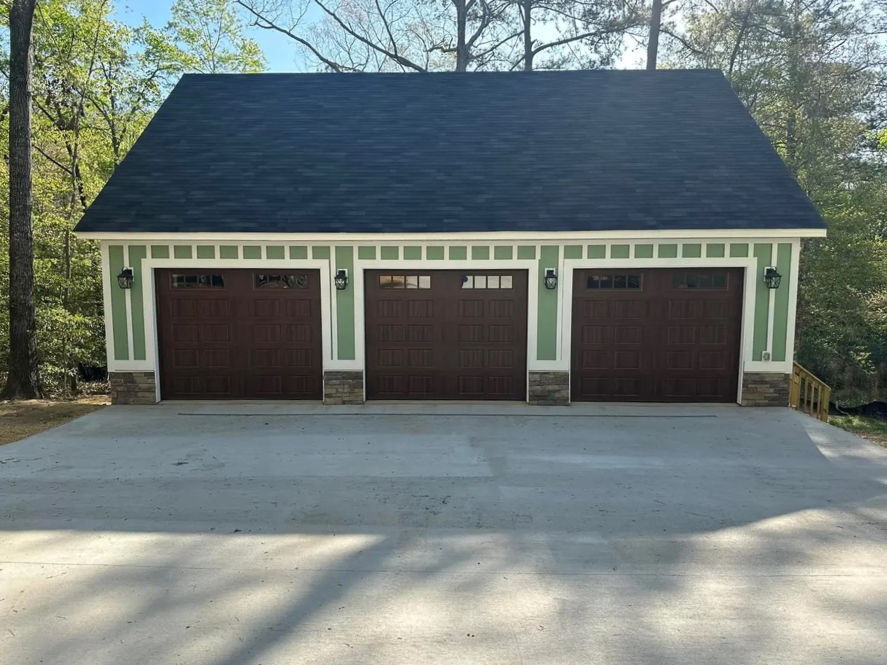 Custom-built three-car garage with stone accents and craftsman-style doors